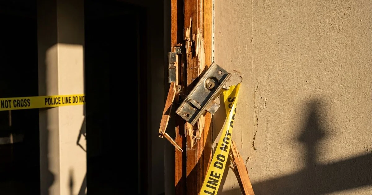 Damaged door frame and broken lock after a residential burglary showing signs of forced entry